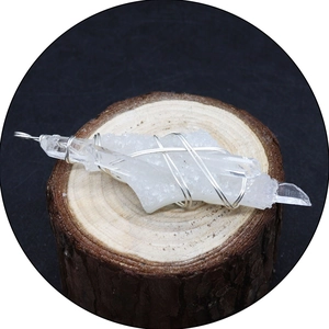 Colgante artesanal de cristal de cuarzo natural con alambre de plata sobre madera