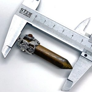 Nahaufnahme eines 5,5 cm Tigerauge-Sechskantanhängers mit Vintage-Metallkappe mit Blumen
