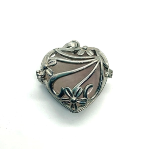 Detailed view of silver heart-shaped flower locket with rose quartz gemstone inlay
