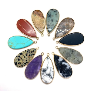 Detalle de colgantes de piedras preciosas en forma de gota con elegante borde de metal dorado