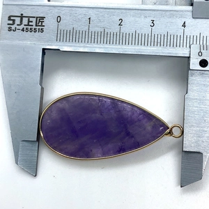 Medición detallada que muestra el ancho de 4,2 cm del gran colgante de piedra lila