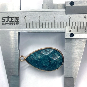 Gedetailleerde meting van een druppelvormige turquoise hanger met goudrand van 25 mm