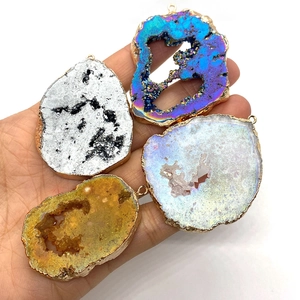 Handgehaltenes Set aus vier unregelmäßigen Druzy-Achat-Anhängern mit Goldrand für DIY