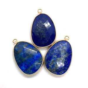 Three faceted teardrop lapis lazuli pendants with gold plated edges and metal rings