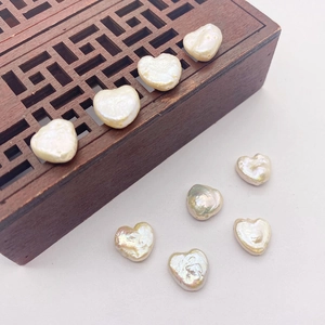 Natural 12mm baroque heart pearl beads with iridescent luster on a vintage wooden box
