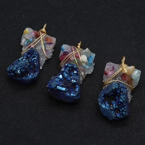 Macro shot of three blue geode crystals wrapped in gold wire on a black background