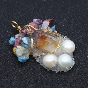 Détail macro du pendentif en forme de raisin avec perles d'eau douce et pierres colorées
