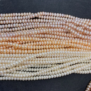 Detailed close-up of AA-grade natural freshwater pearls in white and pink-orange tones