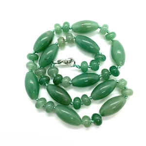 Detail of green natural stone necklace with cylindrical beads and silver metal clasp