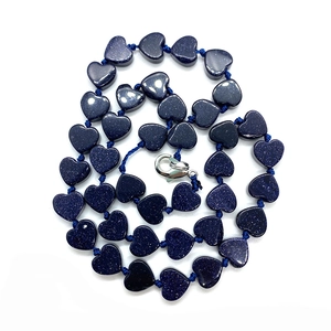 Dettaglio di perle in pietra sintetica blu a forma di cuore con finitura stellata