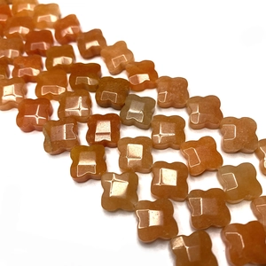 Dettaglio di perle a quadrifoglio arancioni in pietra naturale con finitura lucida