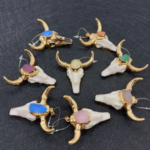 Detail view of colorful natural stone bull skull pendants with gold plating for DIY jewelry
