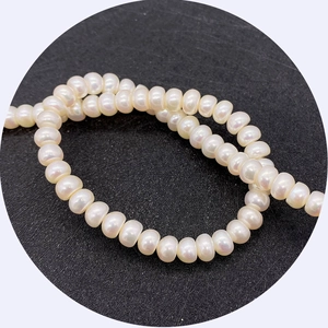 Natural white freshwater pearls necklace strand with glossy finish on a black background