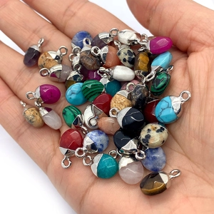 Macro-opname van kleurrijke natuurstenen druppelhangers met zilveren oogjes voor sieraden