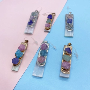 Macro view of rectangular natural stone pendants with colorful inlaid raw crystals