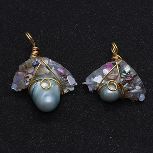 Detail of handmade wire wrapped baroque pearl pendants with iridescent shell inlay