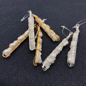 Detailed close-up of wire wrapped natural pearl and crystal pendants in gold and silver wire