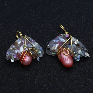 Macro shot of handmade wire-wrapped baroque pearl pendants with colorful resin accents