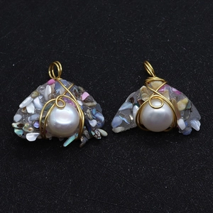 Macro detail of handmade moon-shaped resin pendants with freshwater pearls and wire wrap