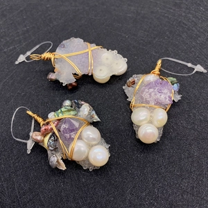 Macro view of handmade wire-wrapped crystal cluster pendant with natural pearls