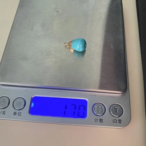Waterdrop-shaped blue stone pendant weighing 1.70g on a digital jewelry scale