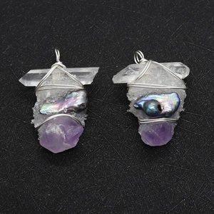 Détail de pendentifs en cristal faits main avec perle baroque sur texture noire