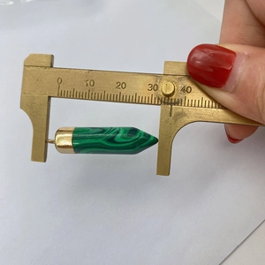 Green malachite style stone pendant measured with brass calipers showing 33mm length