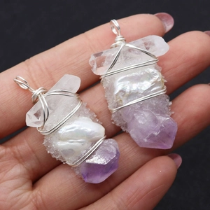 Détail du pendentif artisanal en fil d'argent avec cristal blanc et perle baroque