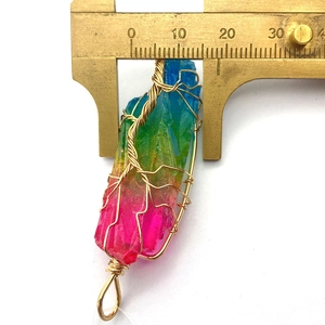 Vue détaillée du pendentif en cristal arc-en-ciel avec fil doré et règle de mesure