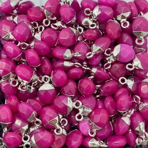 Macro-opname van gefacetteerde fuchsia stenen hangers met zilveren metalen lussen