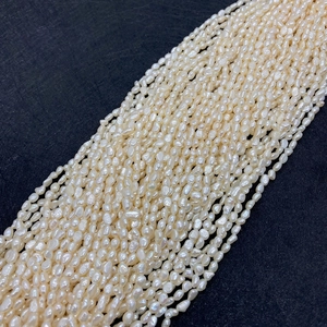 Detailed view of 4-5mm natural baroque freshwater pearl strands with high luster on grey background