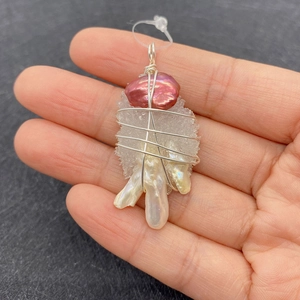 Detailed macro of wire-wrapped baroque pearl and white crystal cluster necklace pendant