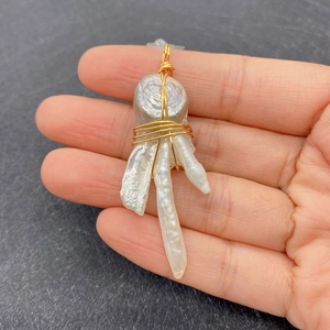 Detailed view of handmade baroque pearl pendant with wire-wrapped gold wire finish