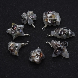 Detailed macro view of handmade wire wrapped pendants with stars and natural pearls