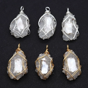 Macro shot of handmade wire wrapped teardrop pendants with natural pearl and druzy crystal