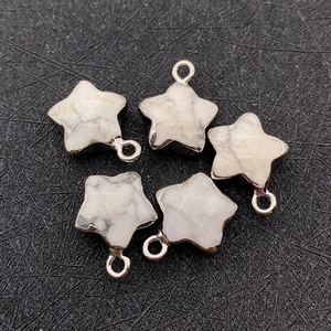 Vue détaillée de pendentifs en pierre étoilée avec bords argentés et boucles de suspension