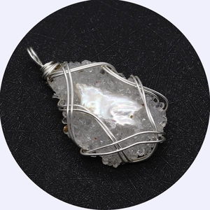 Handmade silver wire-wrapped baroque pearl and crystal cluster pendant on black background