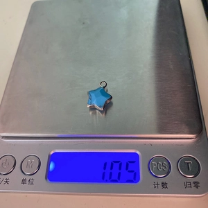 Pendentif en pierre naturelle en forme d'étoile pesant 1,05g sur une balance