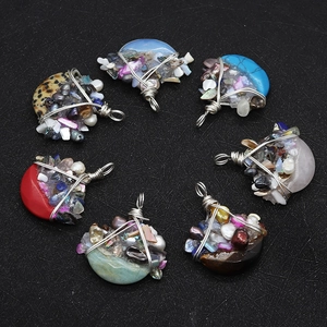 Dettaglio macro di ciondoli a mezza luna in pietra con filo metallico e perle miste