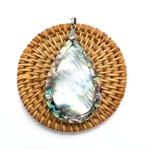 Detailed macro view of natural abalone shell teardrop pendant with iridescent glow