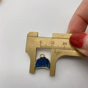 Détail montrant la mesure d'un pendentif en cristal druzy bleu avec bordure dorée