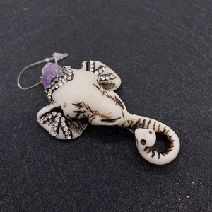 Makroaufnahme von Ganesha-Elefantenanhänger mit eingelegten Strasssteinen und violettem Stein