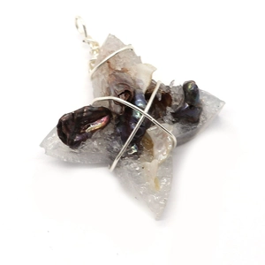 Macro view of handmade leaf-shaped resin pendant with pearl and silver wire wrapping