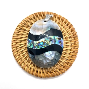 Oval pendant crafted with natural abalone shell and mother of pearl on a woven mat