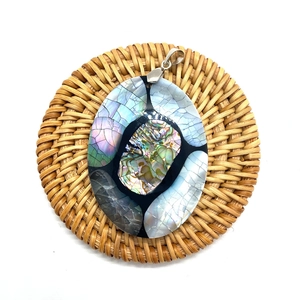 Oval natural abalone shell pendant with mosaic seashell inlay on a rustic woven mat