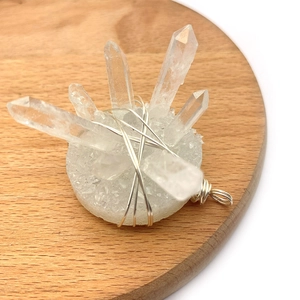 Detailed macro view of natural white crystal cluster pendant with silver wire wrap decor