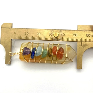 Macro-opname van 7 Chakra natuursteen hanger gemeten met een messing schuifmaat weergave