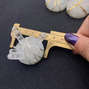 Detail shot of a 40mm raw white crystal cluster pendant with gold and silver wire wrapping