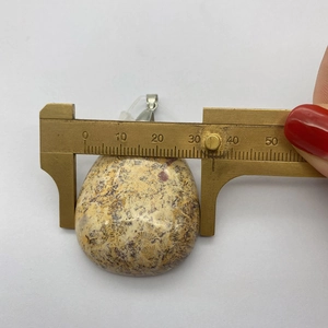 Vue détaillée du pendentif en pierre naturelle brune mesuré avec un pied à coulisse