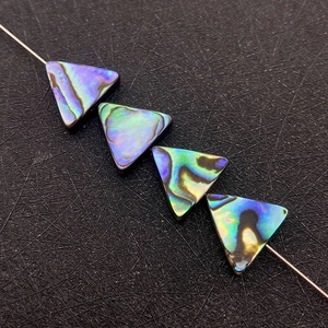 Makroaufnahme von dreieckigen Abalone-Muschelperlen mit farbigem Schillern für DIY-Schmuck